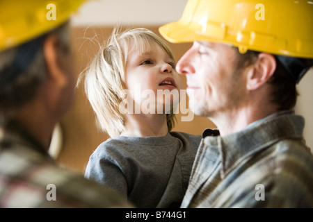 Multi-generation family wearing hard hats, focus sur le père et fils Banque D'Images