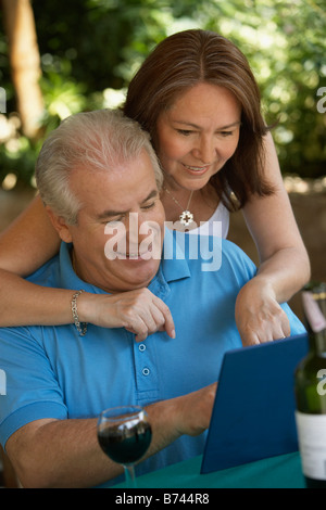 Hispanic couple drinking red wine in cafe Banque D'Images