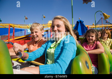 Les jeunes passagers de montagnes russes dans un parc d'amusement Banque D'Images