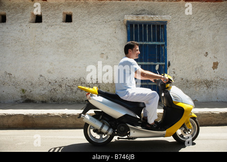 Man riding scooter Banque D'Images