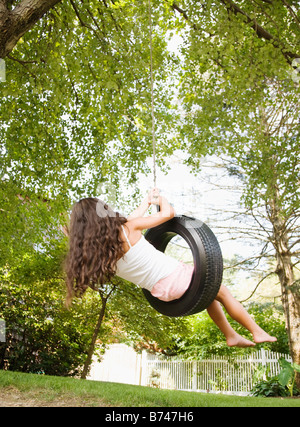 Hispanic girl swinging sur balançoire pneu Banque D'Images