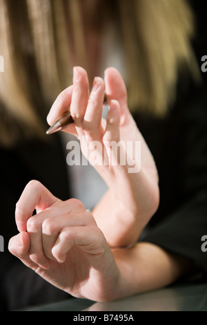 Close-up of hands holding pen and gesturing Banque D'Images