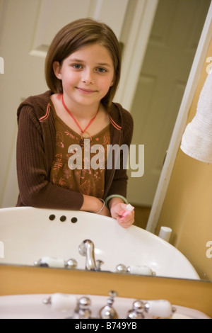 Huit ans, fille, brossage des dents au lavabo de la salle de bains Banque D'Images