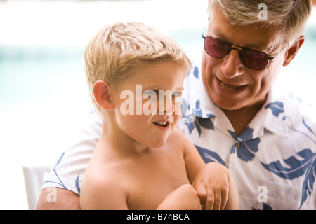 Close-up de petit-fils assis sur les genoux de grand-père Banque D'Images