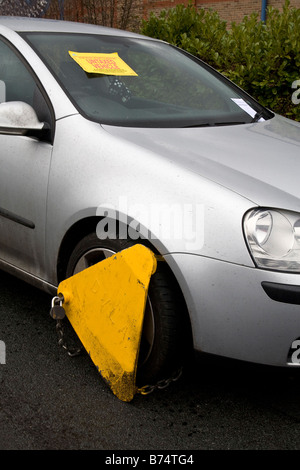 Collier sur roue voiture non taxés avec le préavis prescrit fixé sur le pare brise. Banque D'Images