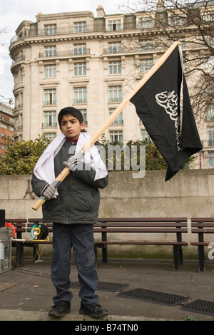 Jeune garçon musulman tenant un drapeau islamique au cours de rassemblement à Marble Arch appelant au djihad Banque D'Images