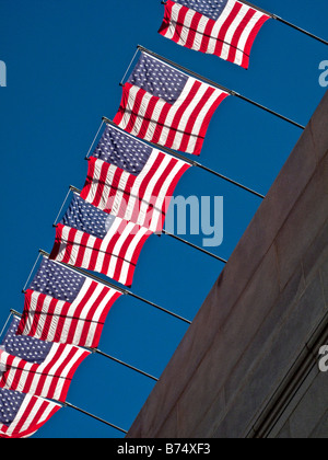 Contre un ciel bleu clair de drapeaux américains dans le soleil à Los Angeles CA Banque D'Images