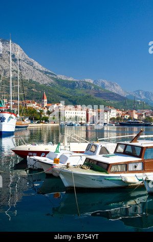 Le port avec une marche au bord de l'eau et des bateaux de pêche dans la région de Makarska Croatie Banque D'Images