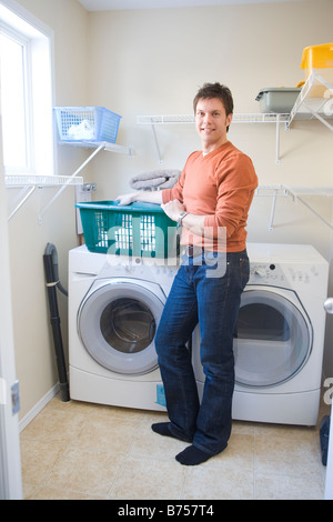 L'homme se place en avant du front loading lave-linge avec des couches en tissu, Winnipeg, Canada Banque D'Images