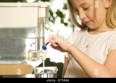 Jeune fille versant l'eau filtrée, Toronto, Canada Banque D'Images