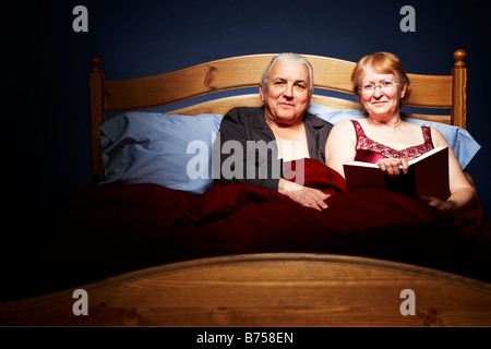 Senior couple cuddling in bed Banque D'Images