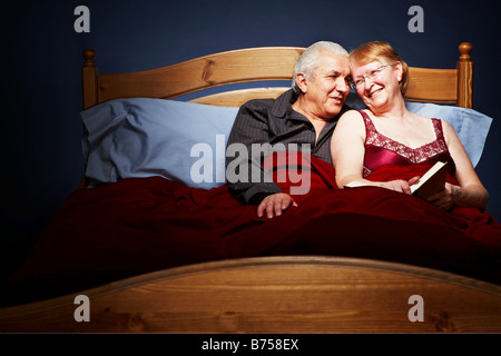 Senior couple cuddling in bed Banque D'Images