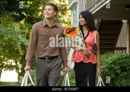 Jeune couple à porter des sacs d'épicerie dans des sacs en tissu, Winnipeg, Manitoba, Canada Banque D'Images