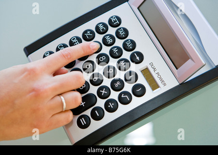 Frau mit einem Taschenrechner calculatrice à l'aide d'une femme, Banque D'Images
