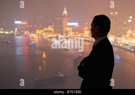 La silhouette d'un homme sur la skyline de Pudong illuminé d'un point de vue élevé. Banque D'Images