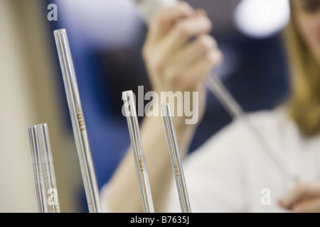 Close-up de 4 pipettes volumétriques avec un scientifique dans l'arrière-plan de pipetage Banque D'Images