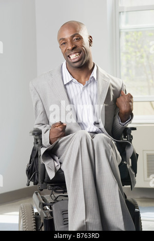 Businessman with Cerebral Palsy assis dans un fauteuil roulant et souriant Banque D'Images