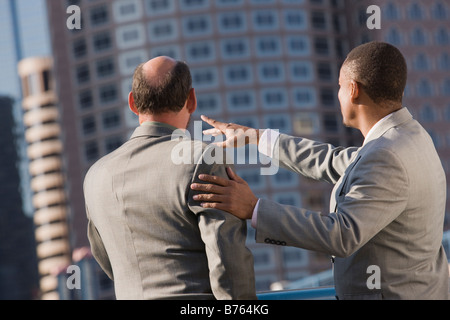 Deux hommes d'affaires à la recherche de bâtiments de bureaux, vue arrière Banque D'Images