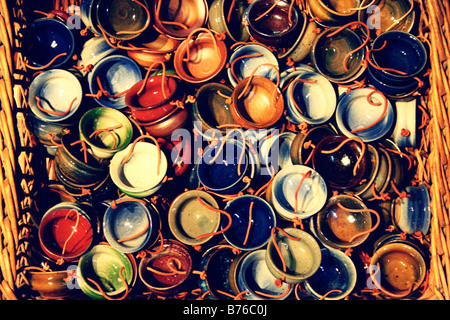 Les petits pots en céramique de couleurs dans un panier en osier en vente en Languedoc en France Banque D'Images