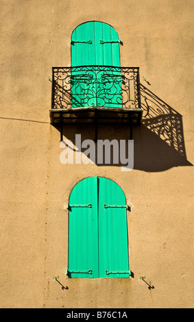 Des volets verts et un balcon jette une ombre sur un mur jaune à Collioure, Perpignan Banque D'Images