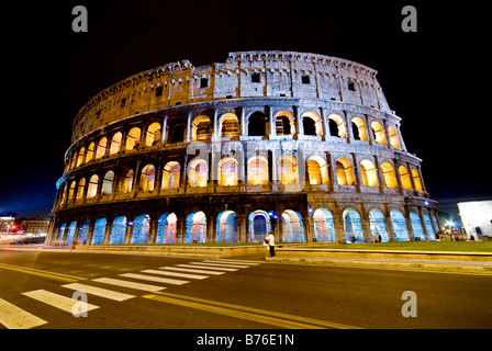 Colisée illuminé la nuit Rome Italie // ROME, Italie — le Colisée illuminé dans le ciel nocturne est un symbole époustouflant de la grandeur de la Rome antique. Cet amphithéâtre emblématique, achevé en 80 après JC, accueillait autrefois des concours de gladiateurs et des spectacles publics. L'éclairage nocturne accentue les détails architecturaux, créant une vue fascinante de l'un des monuments historiques les plus célèbres du monde. Banque D'Images
