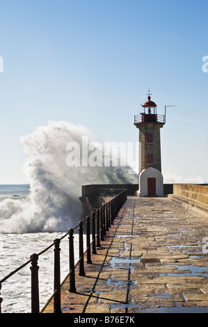 D'énormes vagues se briser contre la base d'un phare Banque D'Images