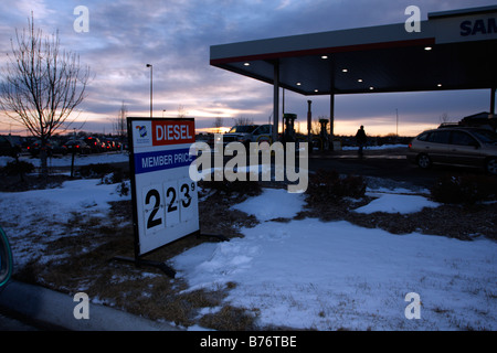 Sam's Club station essence à coucher du soleil montrant : signer et auvent avec des voitures sous les pompes. Banque D'Images