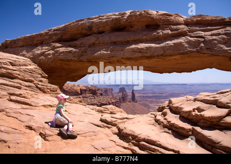 Une petite fille bénéficie d'avis thru Mesa Arch dans l'île dans le ciel district de Canyonlands National Park Utah Banque D'Images