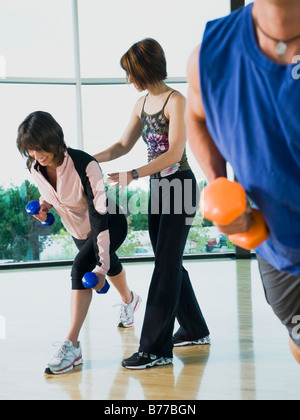 Instructeur de fitness femme aider lunge haltères Banque D'Images