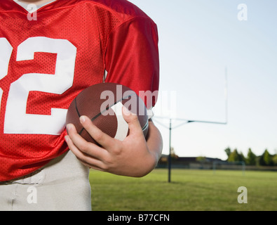 Close up of football player holding football sur terrain Banque D'Images