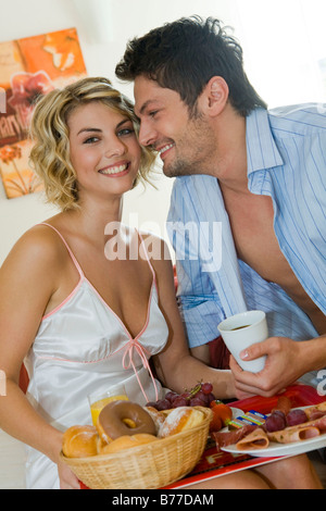 Paar beim gemeinsamen Fruehstueck im Bett, couple having breakfast together in bed Banque D'Images