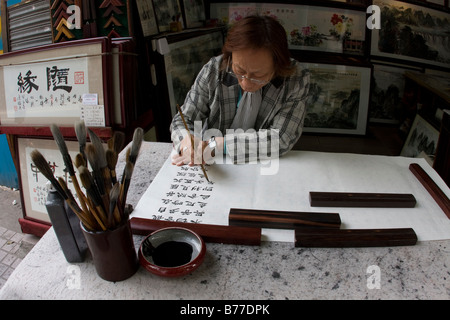 Artiest chinois et propriétaire de boutique assis de la création d'une nouvelle pièce de l'oeuvre à l'aide d'achats Chinois de Canton Guangzhou Guangdong Chine Banque D'Images