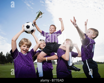 L'équipe de soccer garçons célébrant trophy Banque D'Images