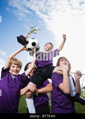 L'équipe de soccer garçons célébrant trophy Banque D'Images