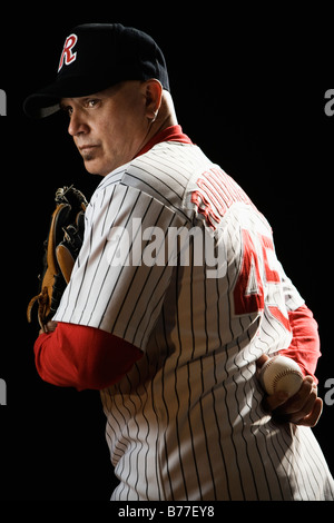 Holding baseball Pitcher behind back Banque D'Images