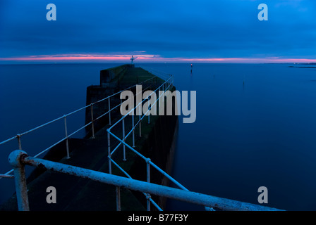 Mur du port et phare dans le pittoresque village de pêcheurs de Pittenweem, East Neuk, Fife, Scotland, UK au crépuscule. Banque D'Images