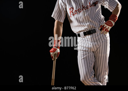 Portrait Portrait de baseball player leaning on bat Banque D'Images