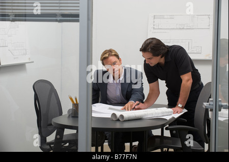 Architects reviewing blueprints Banque D'Images