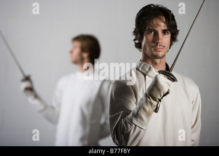 Portrait d'escrimeurs holding fencing foils Banque D'Images