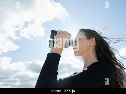 Woman looking through binoculars Banque D'Images
