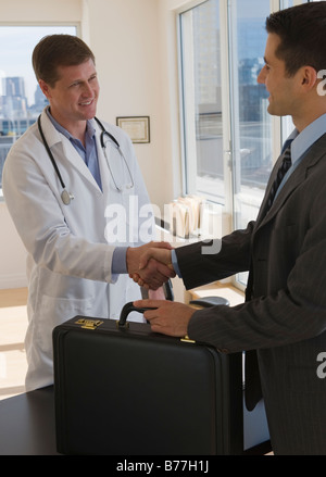 Médecin et businessman shaking hands Banque D'Images