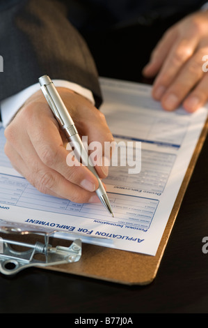 L'homme de remplir formulaire de demande d'emploi Banque D'Images