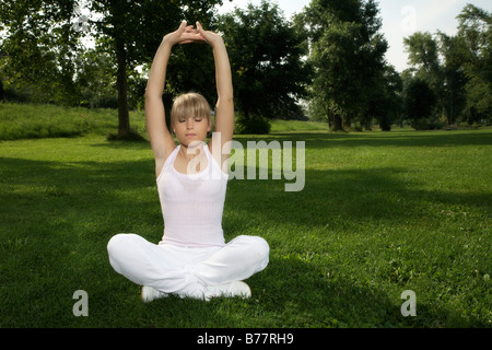 Jeune, blond foncé woman stretching Banque D'Images