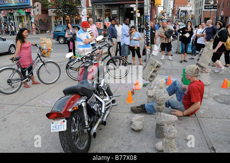Une petite foule se rassemble autour d'un artiste de rue/interprète/sculpteur dans le quartier branché de la rue Queen Ouest quartier Banque D'Images