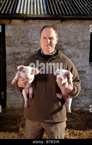 Un agriculteur AVEC UNE PAIRE DE GLOUCESTER VIEUX SPOT PORCELET Banque D'Images