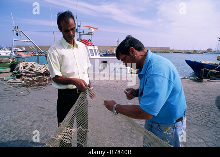 Italie, Calabre, Crotone, port, pêcheurs réparant les filets Banque D'Images
