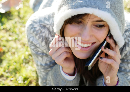 Monsieur Portrait of a cute et douce jeune fille adolescente espagnol parlant avec son téléphone dans le parc Banque D'Images