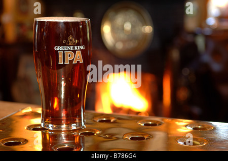 Pinte de vraie bière avec feu ouvert derrière dans un pub anglais traditionnel Banque D'Images