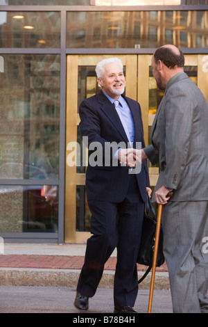 Deux businessmen shaking hands in front of office building Banque D'Images