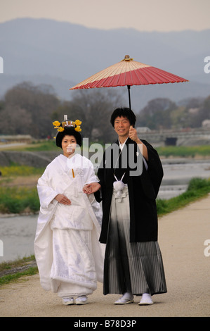 Mariage traditionnel japonais couple wearing kimonos, mariée avec coiffure de mariage, le marié tenant un parasol sur papier traditionnel Banque D'Images